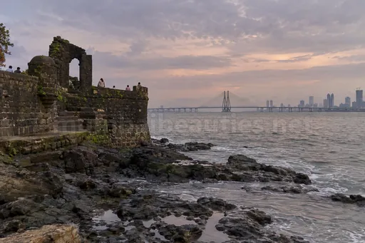 Bandra Fort's old stone walls at sunset, Sea Link cables across the water – Bandra escorts