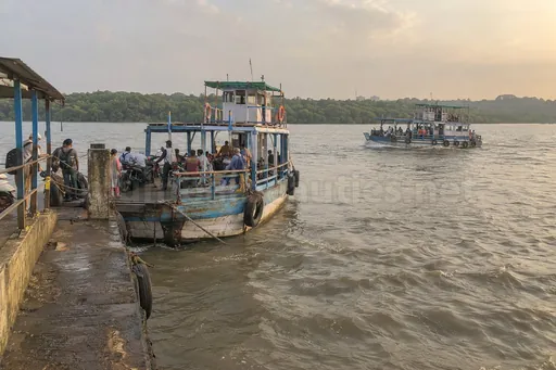 Borivali–Gorai ferry jetty with wooden boats, scooters waiting and mangroves, Borivali escorts