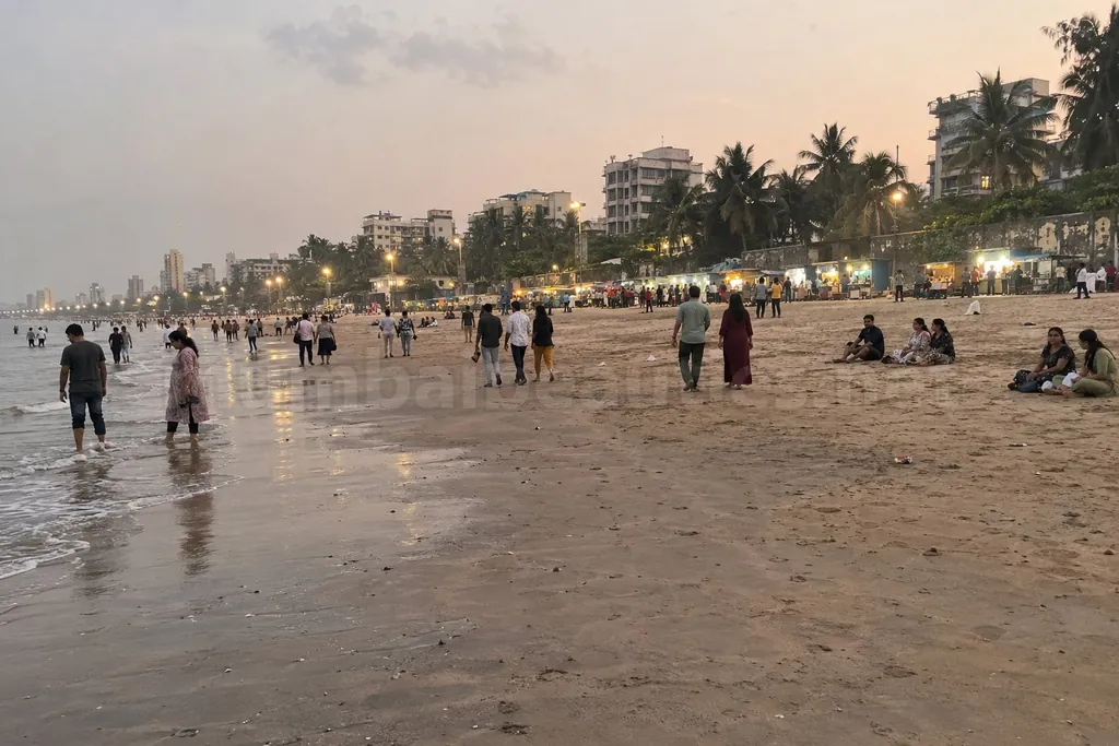 Juhu escorts: Juhu beach in the evening, crowds on the sand and food stalls lit with bulbs