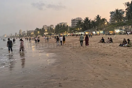 Juhu escorts: Juhu beach in the evening, crowds on the sand and food stalls lit with bulbs
